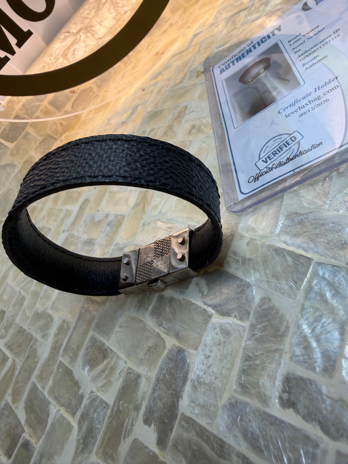 Louis Vuitton bracelet worn open showing black band and clasp