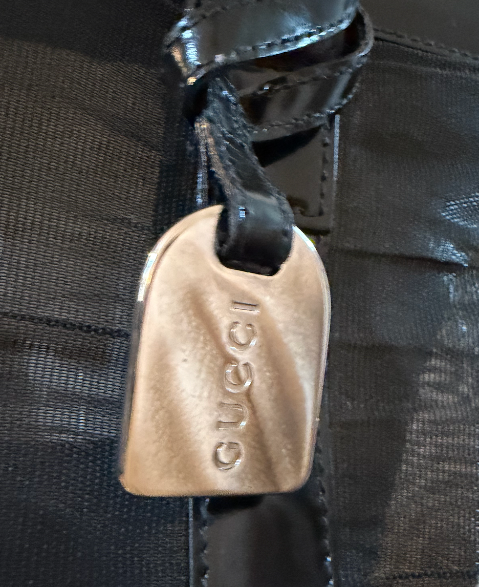 Gucci Black Mesh Tote - close up of embossed Gucci tag hardware