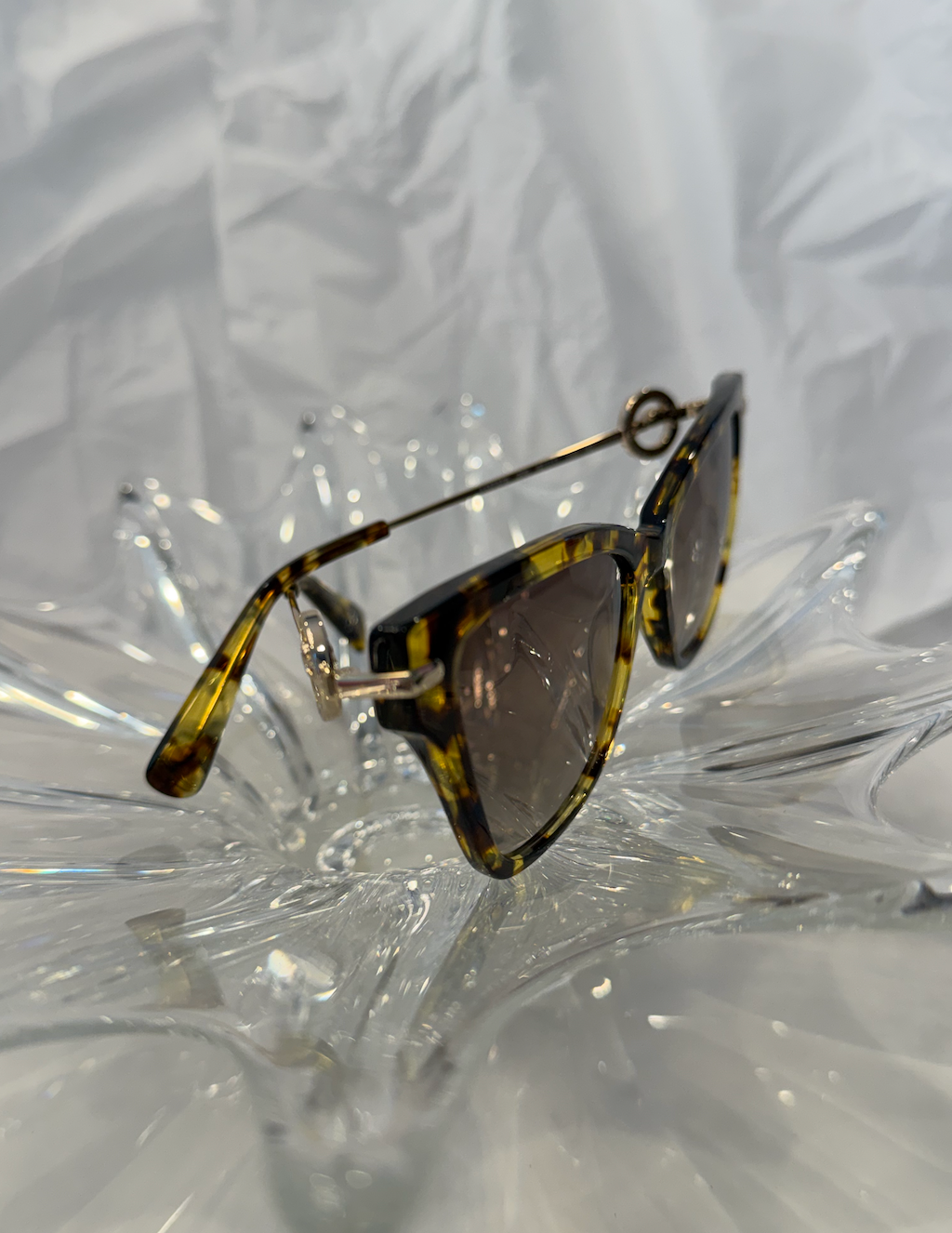 Longchamp LO737S cat eye sunglasses side view showing gold brow bar on crystal display