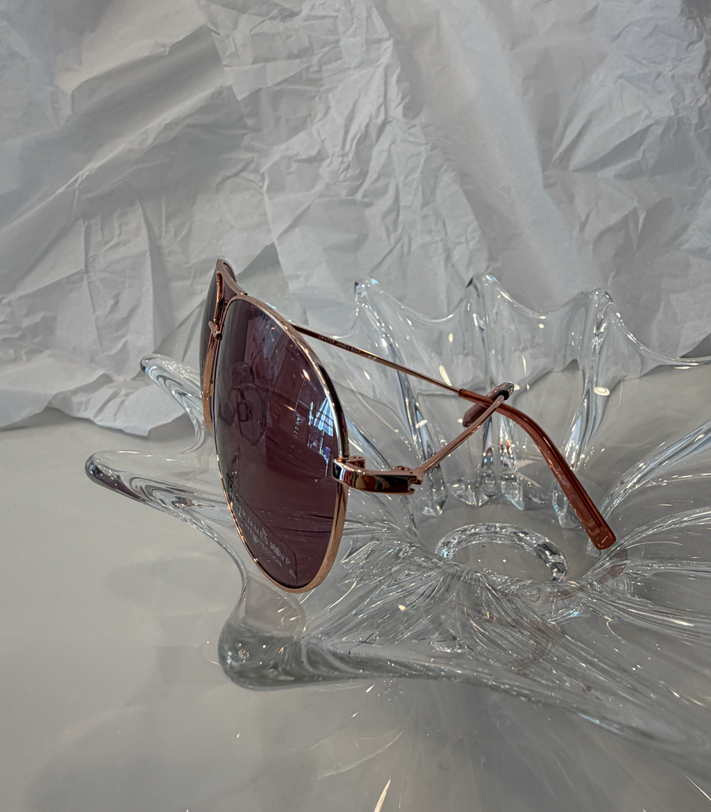 Draper James DJ9028 rose gold aviator sunglasses side view on crystal display