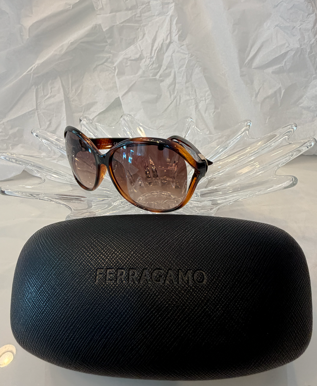 Salvatore Ferragamo oversized butterfly sunglasses side angle view on crystal display showing tortoise frame and Ferragamo script logo