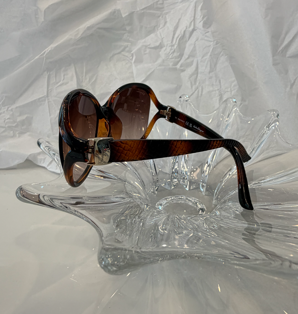 Salvatore Ferragamo oversized butterfly sunglasses front view on crystal display showing brown gradient lenses