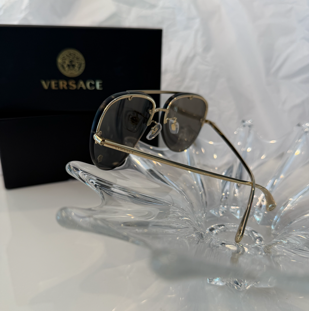Versace MOD 2231 gold rimless aviator sunglasses back angle view on crystal display