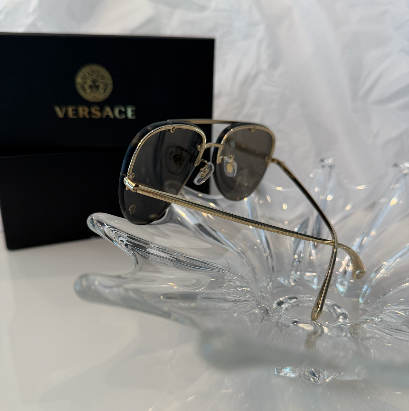 Versace MOD 2231 gold rimless aviator sunglasses back angle view on crystal display