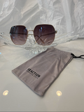 Kenneth Cole Reaction KC3002 gold geometric sunglasses side view on crystal display