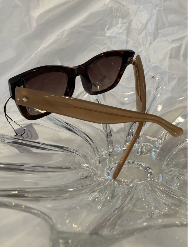 Kate Spade gold spade logo rivet close-up on taupe renewed acetate temple