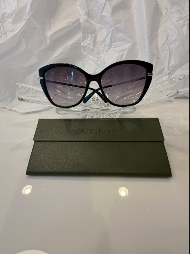 Longchamp LO627S black cat-eye sunglasses back view with temples crossed on crystal display