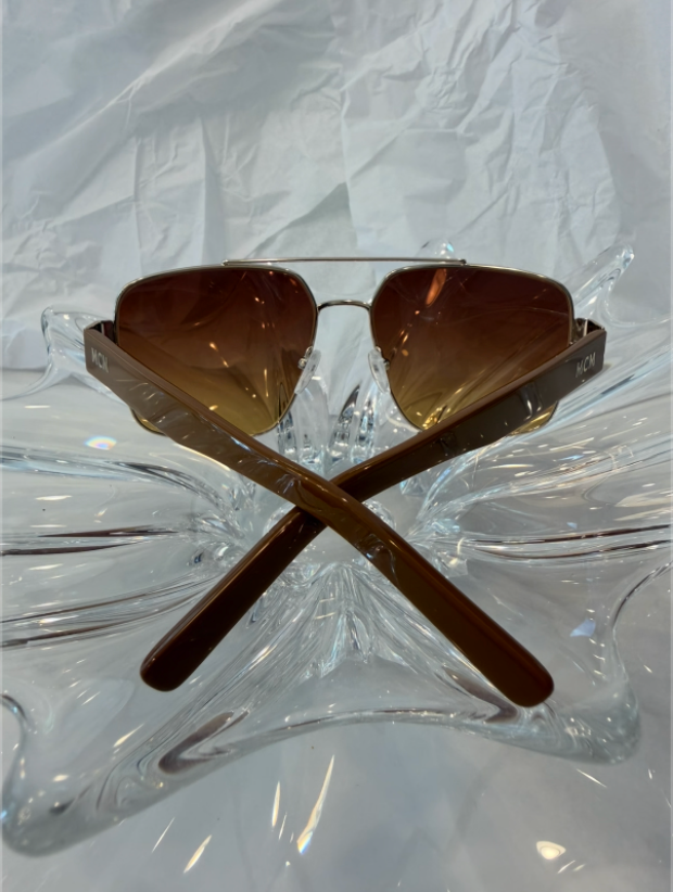 MCM MW0008 gold square aviator sunglasses back view with temples crossed on crystal display