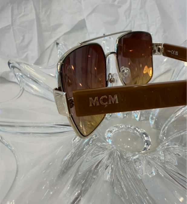 MCM MW0008 temple close-up showing embossed MCM gold logo on brown tortoise acetate with CE UKCA certification