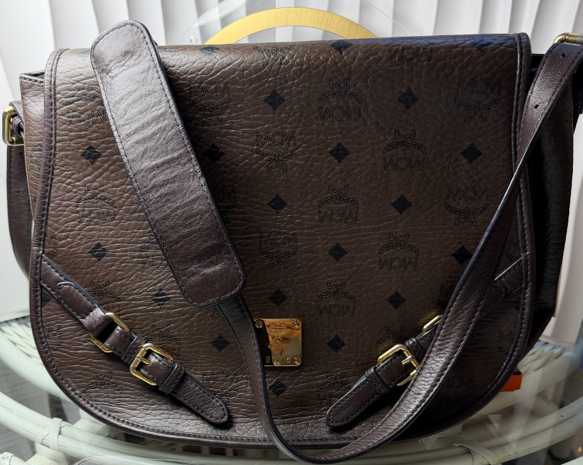 MCM saddle bag front flap with gold MCM plaque and adjustable shoulder strap