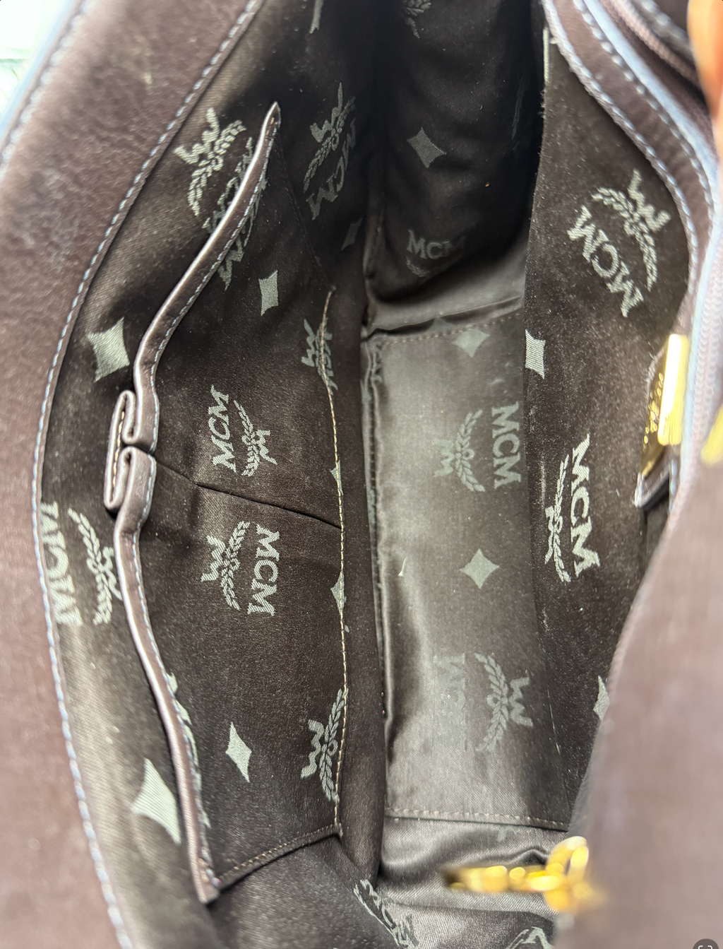 MCM bag interior zip pocket with gold MCM zipper pull and logo patch