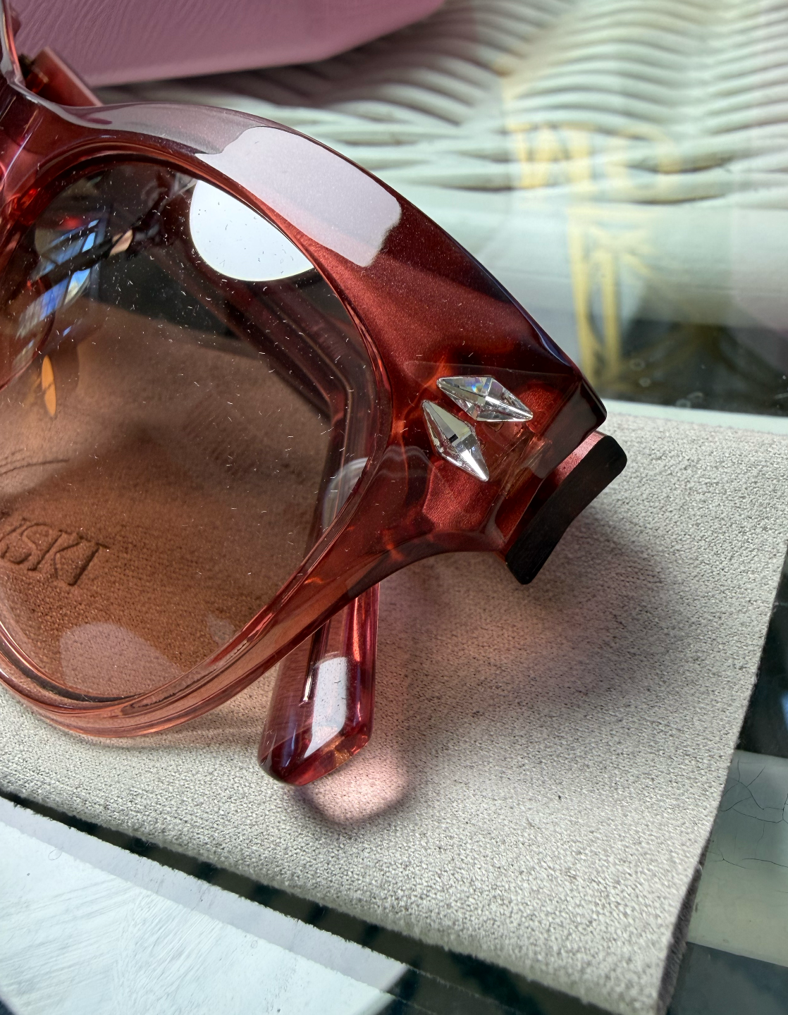 Swarovski cat-eye sunglasses rear view showing clear blush pink temples crossed