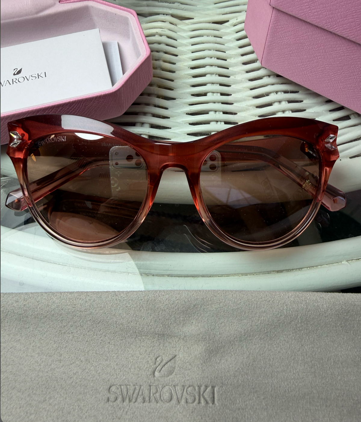 Close-up of Swarovski crystal on front corner of cat-eye frame with Swarovski logo engraved on lens